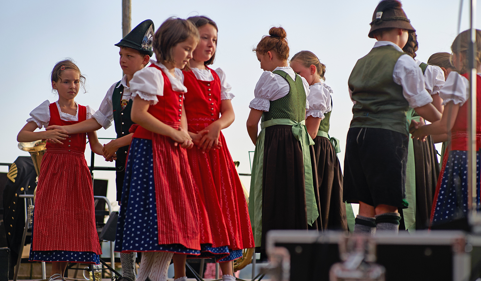 Kinder in Tracht stehen auf der Bühne, bereit für eine Aufführung/Tanz.