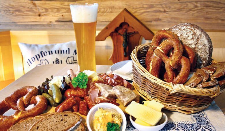 Brotzeitteller mit Brezen, Brotscheiben in einem Korb, verschiedene Wurst und Butter